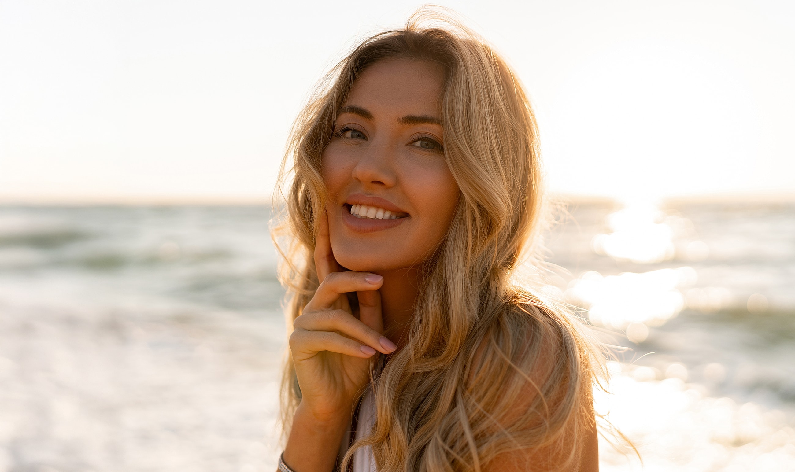 Beverly Hills plastic surgery model by the ocean at sunset.